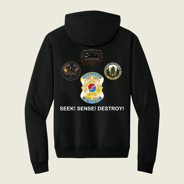 A black zip-up hoodie shown from the back, featuring four military-style insignia patches and the text 'SEEK! SENSE! DESTROY!' printed in white. The background is a solid light beige color.