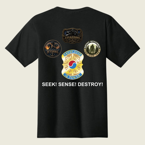 A black short-sleeve t-shirt shown from the back, featuring four military-style insignia patches and the text 'SEEK! SENSE! DESTROY!' printed in white on a light beige background.