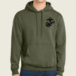An olive green pullover hoodie with a black US Marine Corps Eagle, Globe, and Anchor emblem printed on the left chest, shown on a model wearing blue jeans against a light beige background.