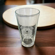 engraved pint glass on table